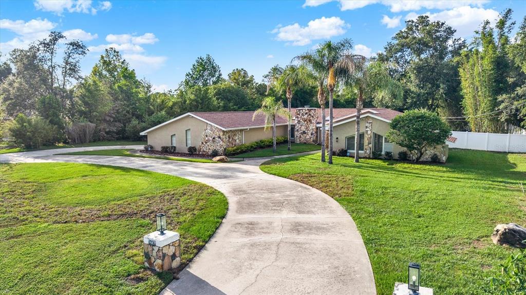 7487 River Country Drive Weeki Wachee, FL 34607 - Photo 5 of 53 a view of house with garden and tall trees