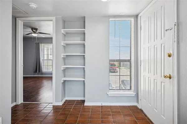 a view of an empty room with cabinet and a window