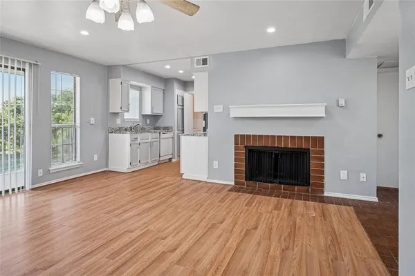 a view of an empty room with a fireplace and window