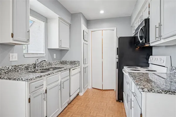 a kitchen with stainless steel appliances granite countertop a refrigerator and a stove