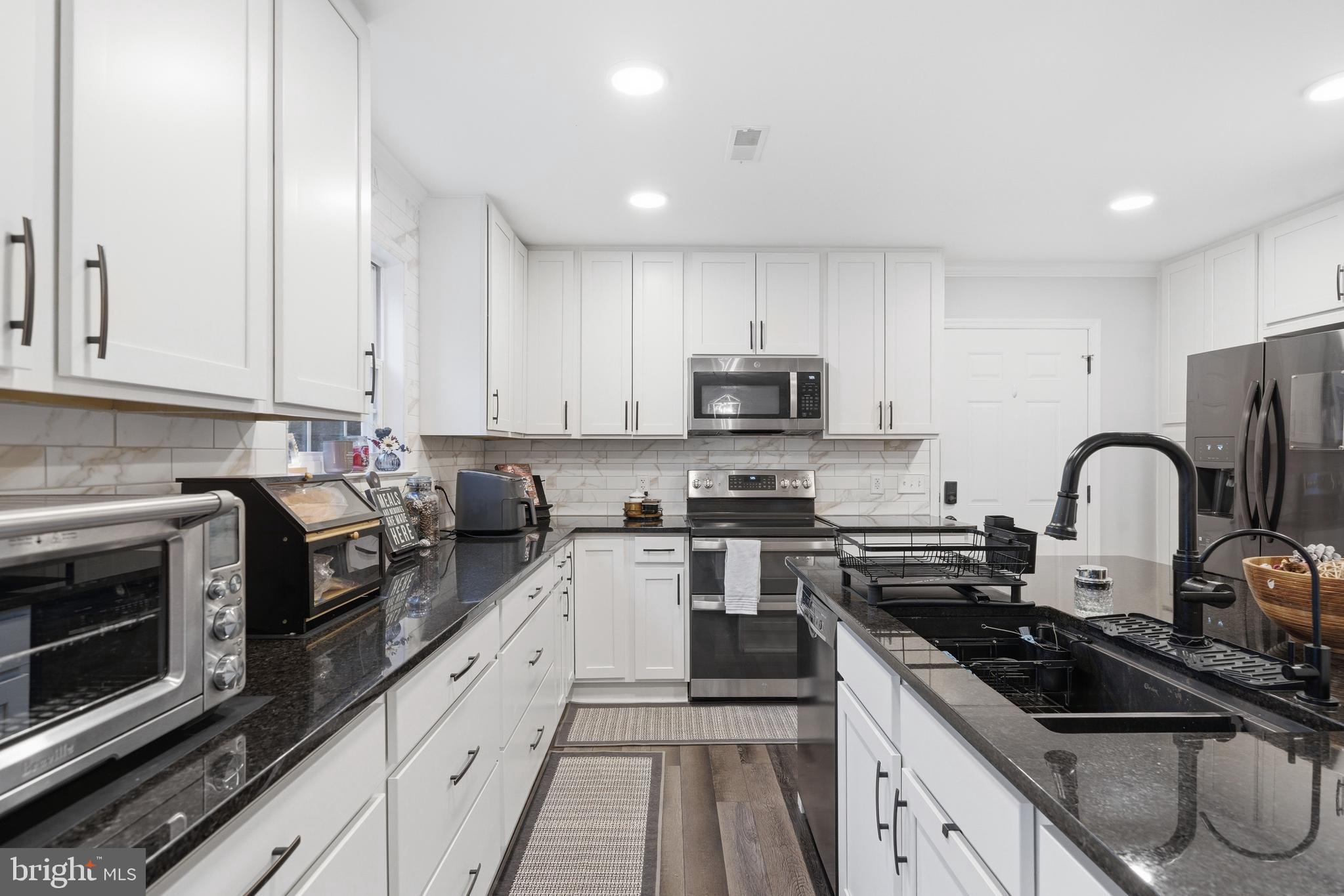 2550 Port Tobacco Road Nanjemoy, MD 20662 - Photo 8 of 70 a kitchen with stainless steel appliances granite countertop white cabinets sink and stove