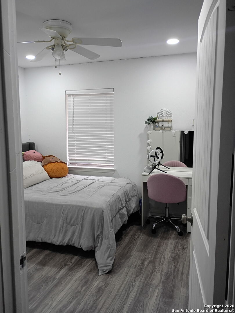 6723 Raintree Path San Antonio, TX 78233 - Photo 7 of 11 a bedroom with a bed and wooden floor