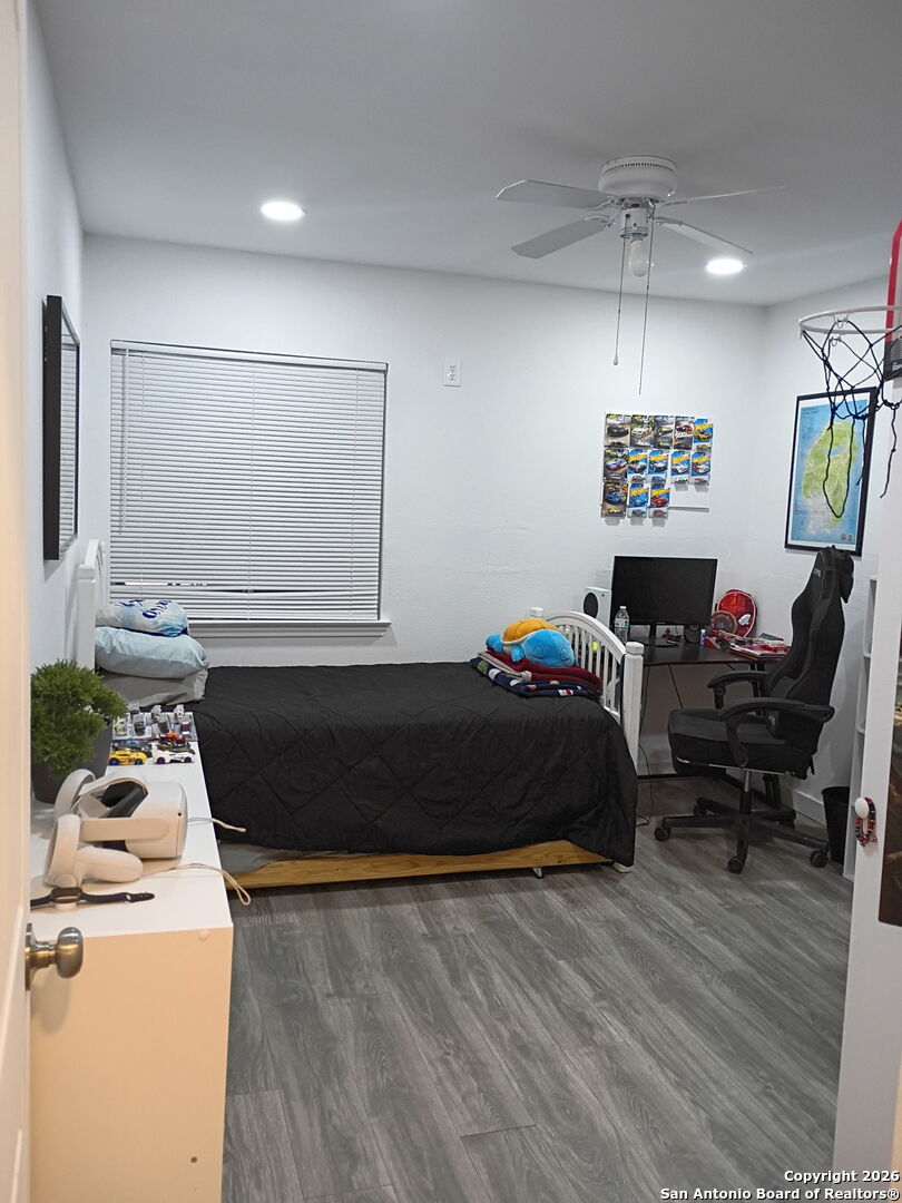 6723 Raintree Path San Antonio, TX 78233 - Photo 9 of 11 a bedroom with a bed and wooden floor