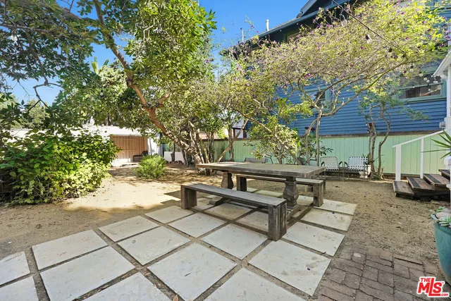 a view of a patio with a table and chairs under an umbrella