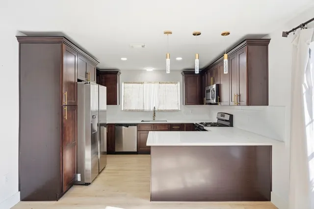 a kitchen with stainless steel appliances granite countertop a refrigerator a sink a stove and oven