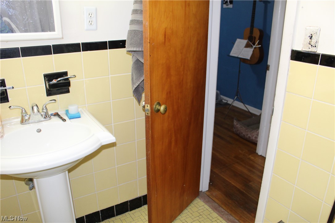 1292 Ford Road Lyndhurst, OH 44124 - Photo 22 of 25 Bathroom featuring tile style floors, sink, tasteful backsplash, and tile walls