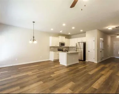 a view of kitchen with kitchen island wooden cabinets and refrigerator