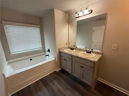 a bathroom with a tub sink and mirror