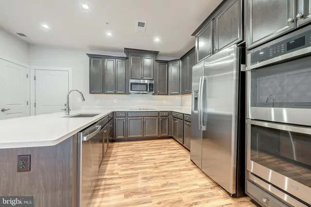 a large kitchen with a sink and refrigerator