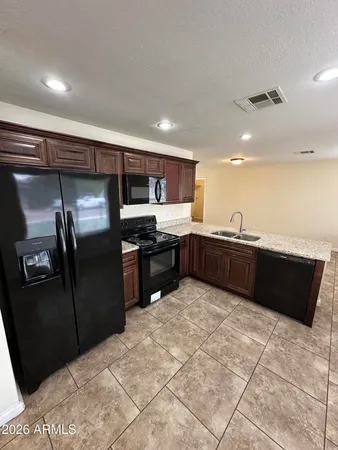a large kitchen with stainless steel appliances granite countertop a refrigerator and a sink