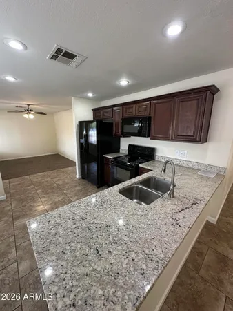 a kitchen with stainless steel appliances granite countertop a sink a stove and a refrigerator