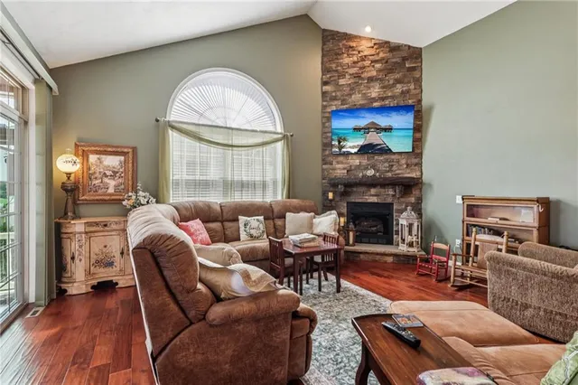 a kitchen with stainless steel appliances granite countertop a sink a stove and a wooden floors