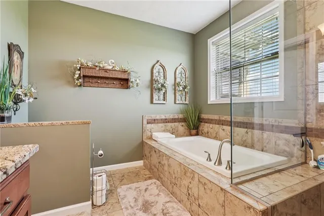a white bath tub sitting in a bathroom next to a window