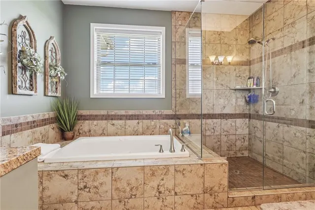 a bathroom with a granite countertop sink a mirror and shower