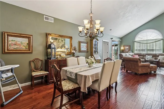 a view of a dining room with furniture a chandelier and wooden floor
