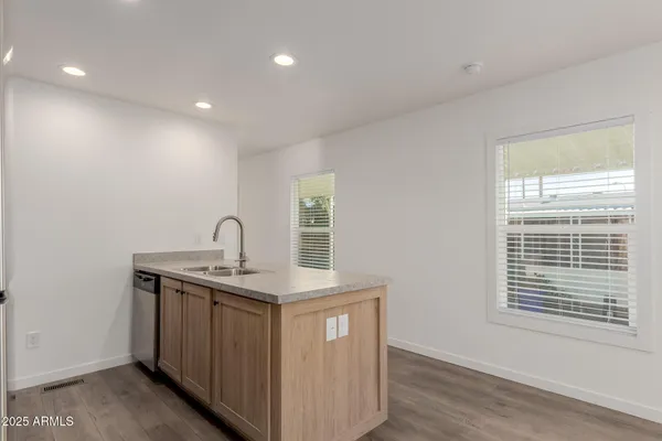 a view of a kitchen with a sink dishwasher and wooden floor