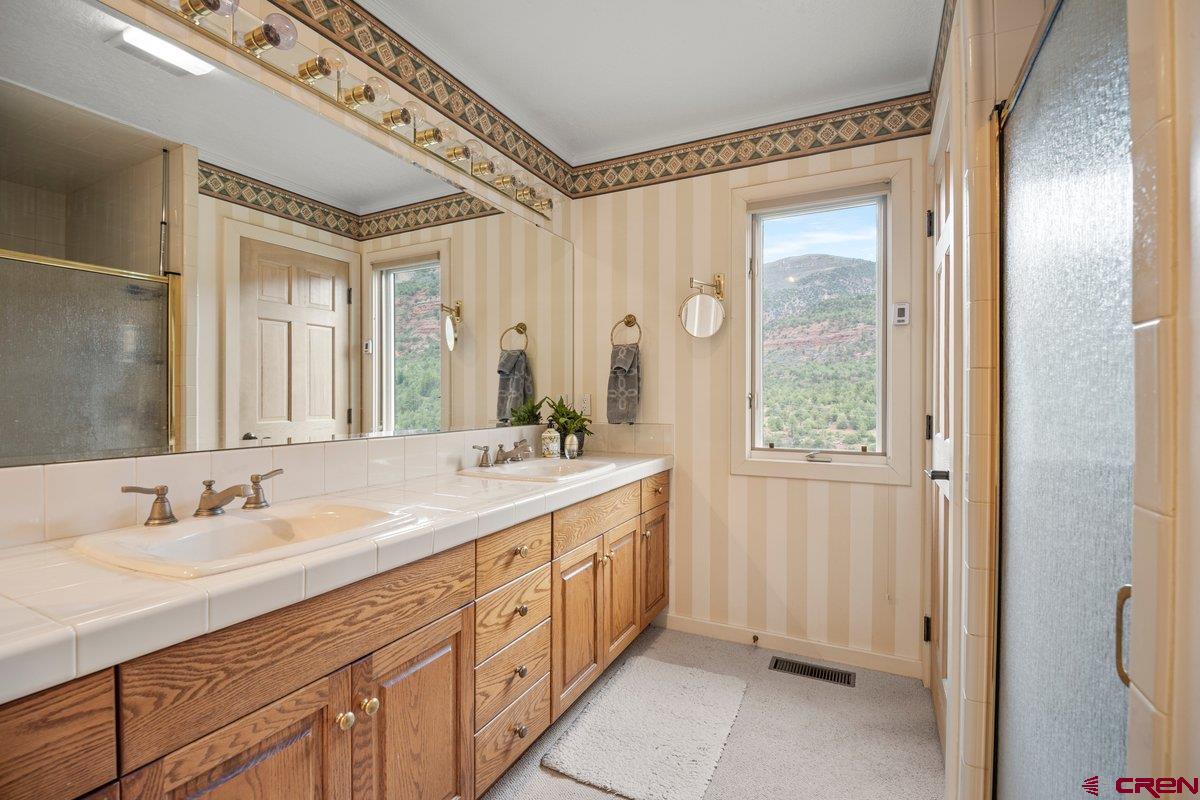 2490 County Road 17 Ridgway, CO 81432 - Photo 23 of 26 a spacious bathroom with a double vanity sink and a mirror