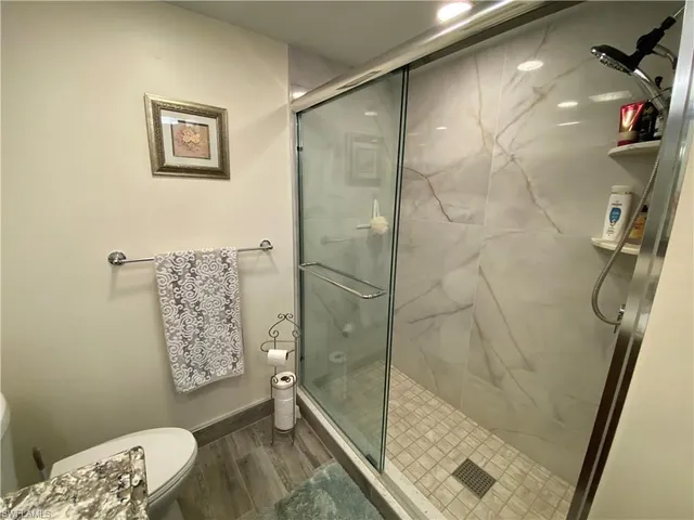 a kitchen with stainless steel appliances kitchen island granite countertop a sink a refrigerator and chairs