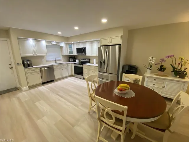 a kitchen with stainless steel appliances kitchen island granite countertop a sink refrigerator and stove