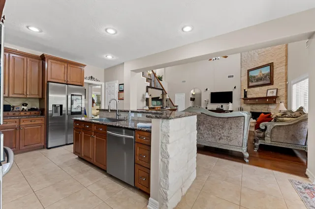 a kitchen with kitchen island granite countertop a sink counter top space appliances and cabinets