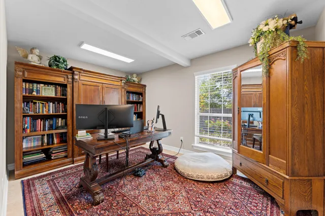 a living room with furniture a bookshelf and a window