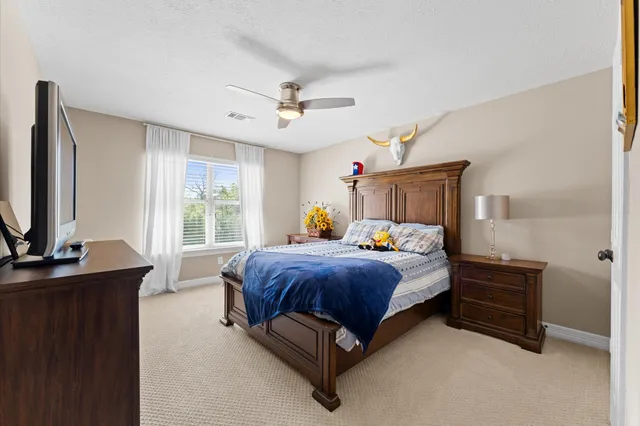 a bed room with a bed window and a flat tv screen