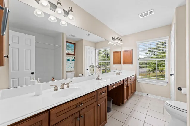 a spacious bathroom with a granite countertop sink mirror and a bathtub
