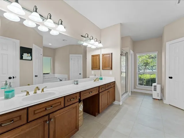 a spacious bathroom with a double vanity sink mirror and chandelier