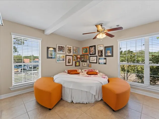 a bedroom with furniture and a large window