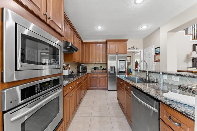 a large kitchen with stainless steel appliances granite countertop a stove and a sink