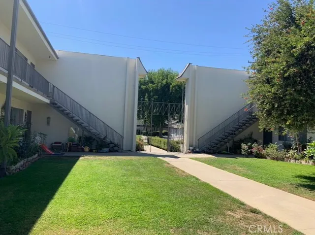 a view of a house with a yard and potted plants