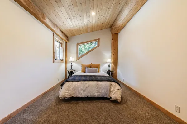 a bedroom with a bed lamp and a large window