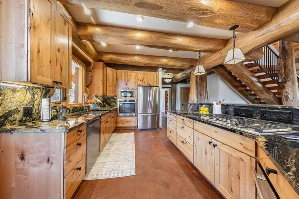 a kitchen with stainless steel appliances granite countertop a stove a sink and a refrigerator