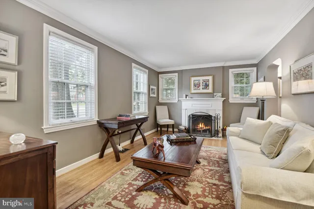 a living room with furniture a fireplace and large windows