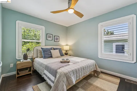 a bedroom with a bed wooden floor and a window