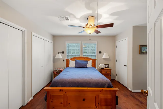 a large bedroom with a bed and wooden floor