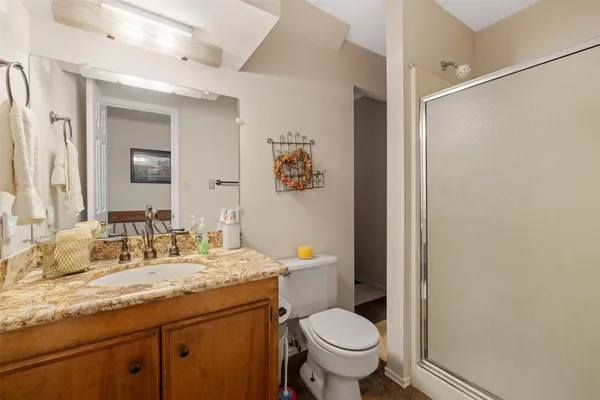 a bathroom with a granite countertop sink toilet and a mirror
