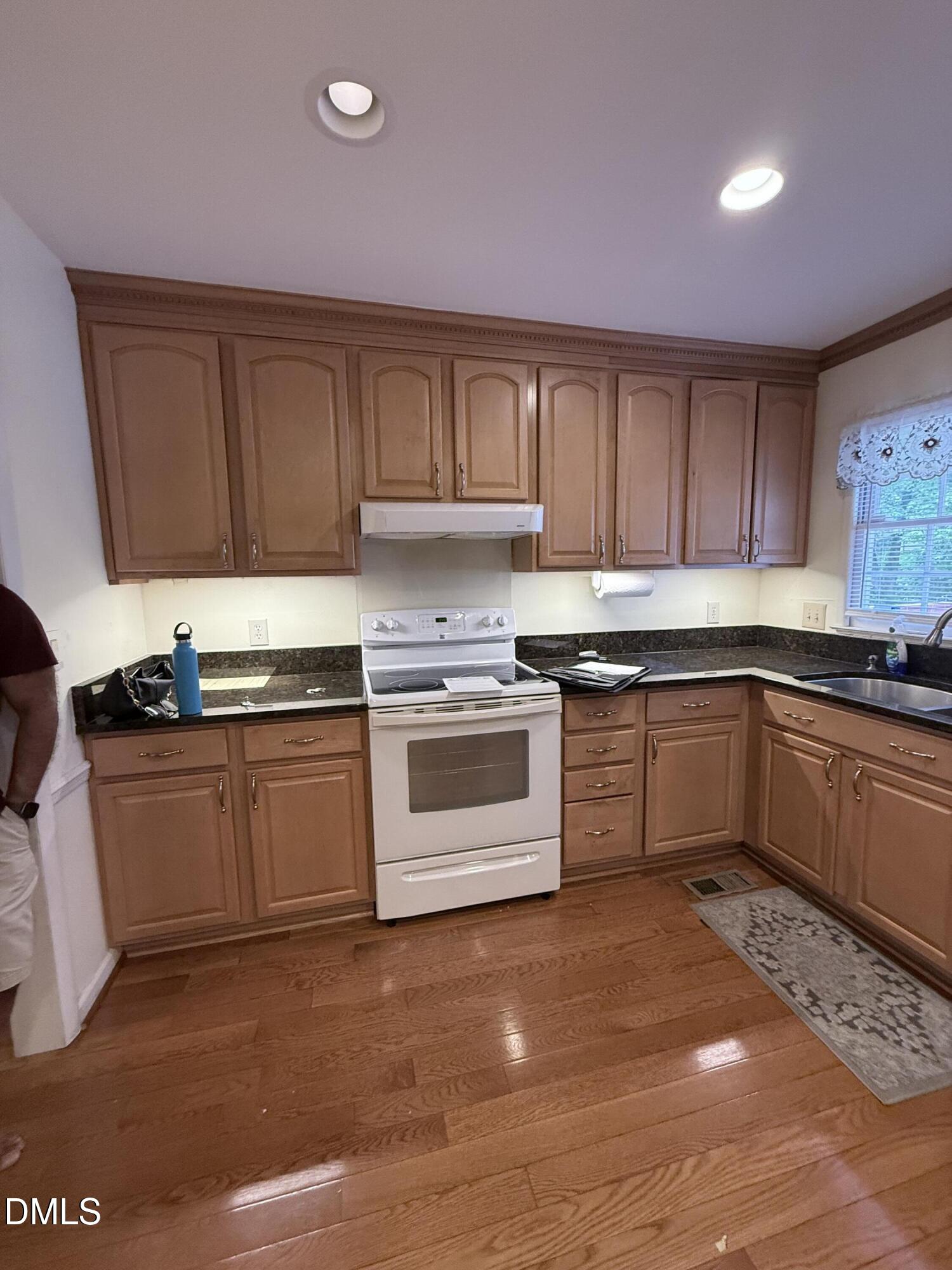 1010 Wyldewood Road Durham, NC 27704 - Photo 3 of 26 a kitchen with granite countertop a stove top oven sink and cabinets