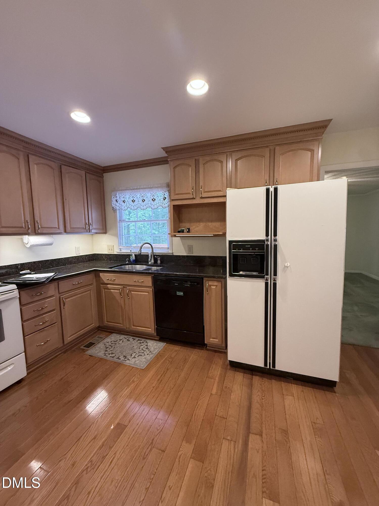 1010 Wyldewood Road Durham, NC 27704 - Photo 4 of 26 a kitchen with a sink a refrigerator and wooden floor