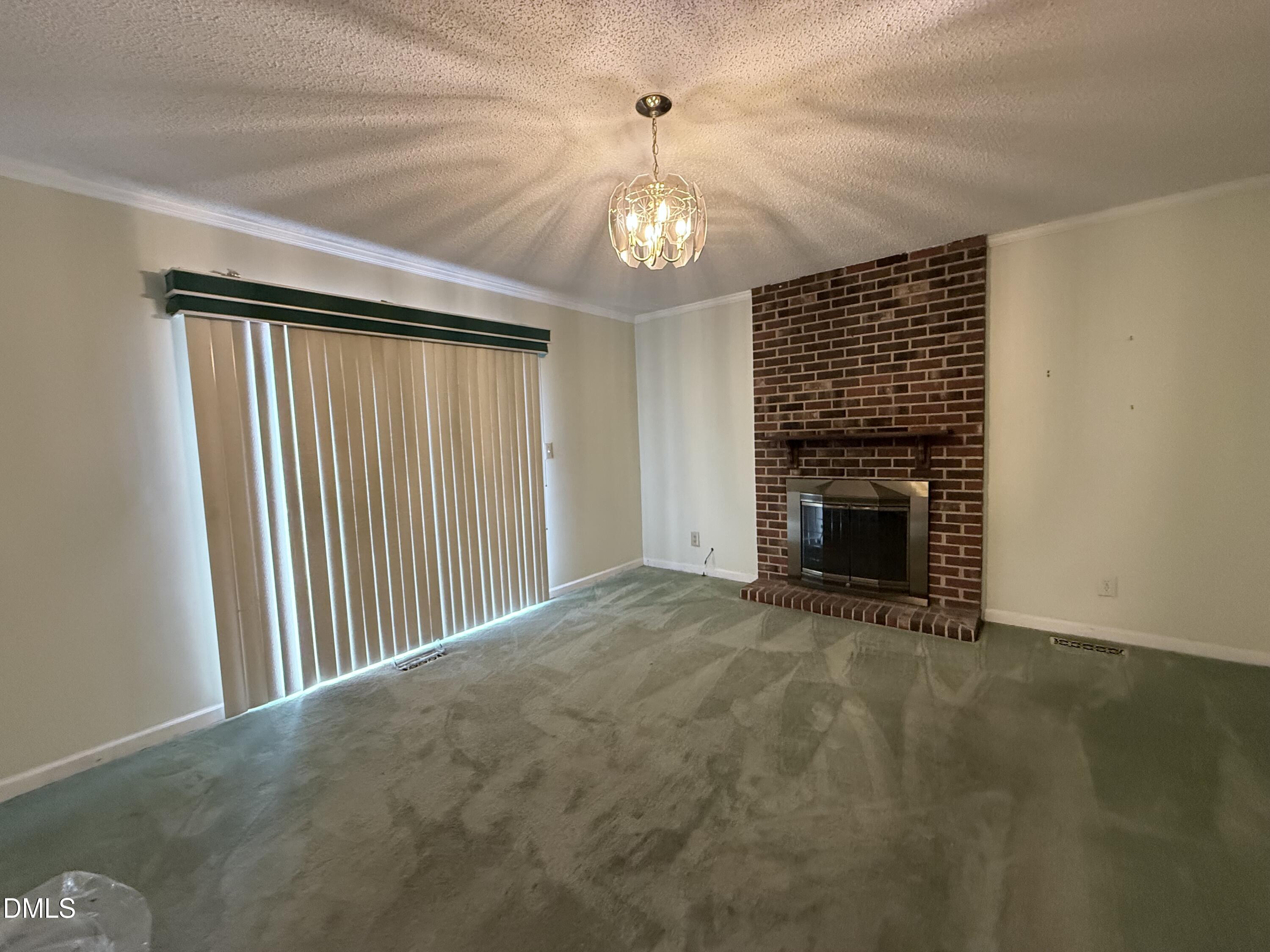 1010 Wyldewood Road Durham, NC 27704 - Photo 9 of 26 a view of an empty room with a fireplace and a window