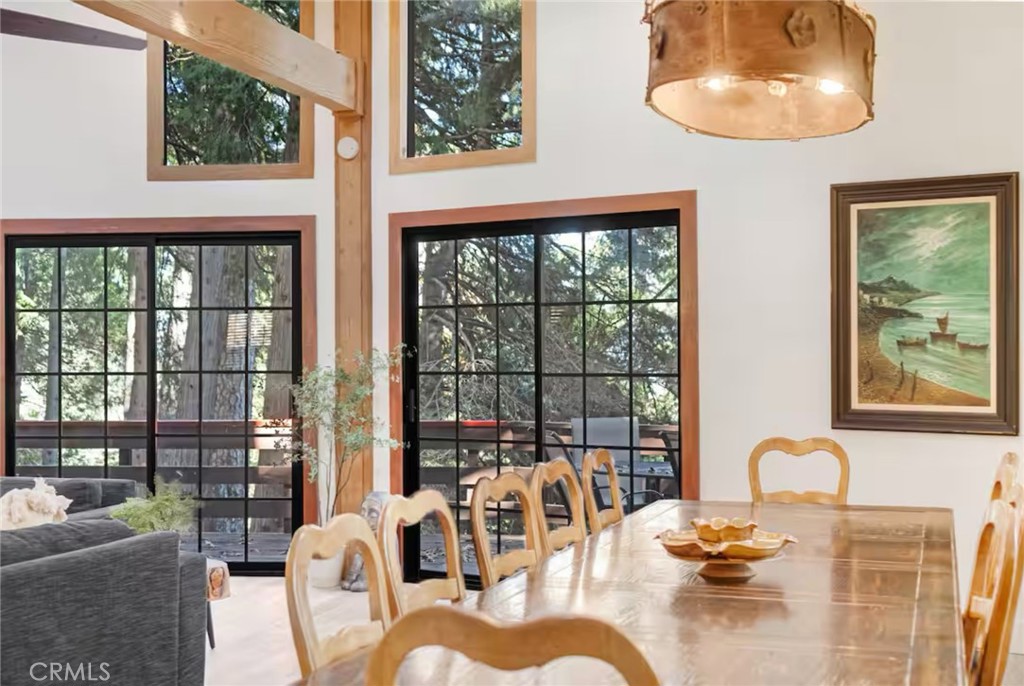 764 Fern Road Lake Arrowhead, CA 92385 - Photo 22 of 60 a dining room with furniture a chandelier and a large window
