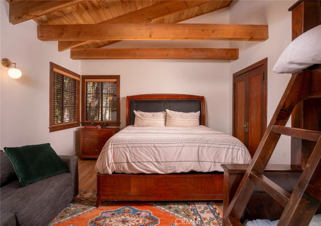 764 Fern Road Lake Arrowhead, CA 92385 - Photo 26 of 60 a bedroom with a bed and wooden floor