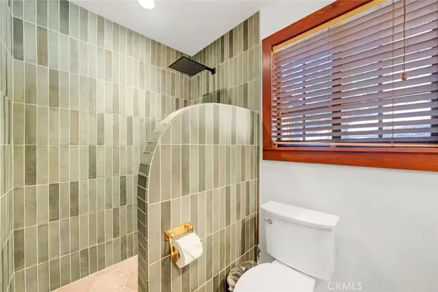 a living room with couch a dining table and chairs with dishwasher