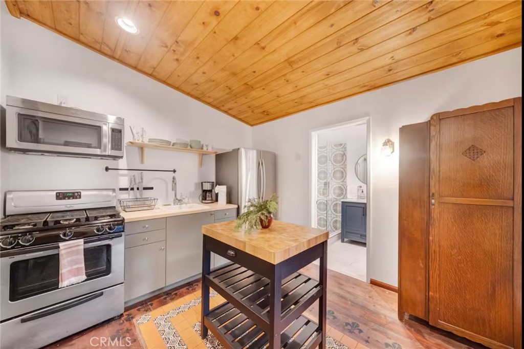 764 Fern Road Lake Arrowhead, CA 92385 - Photo 49 of 60 a kitchen with stainless steel appliances a stove a sink dishwasher a refrigerator white cabinets and wooden floor