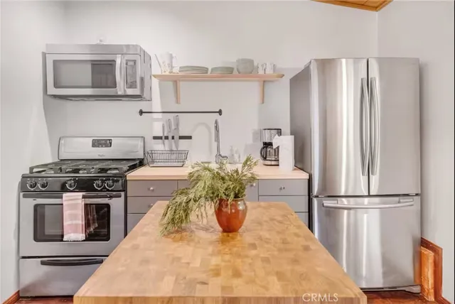 a view of a house with a small yard and a large tree