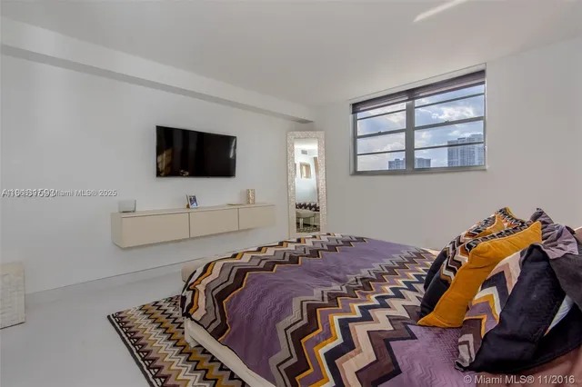a bedroom with a bed and flat screen tv