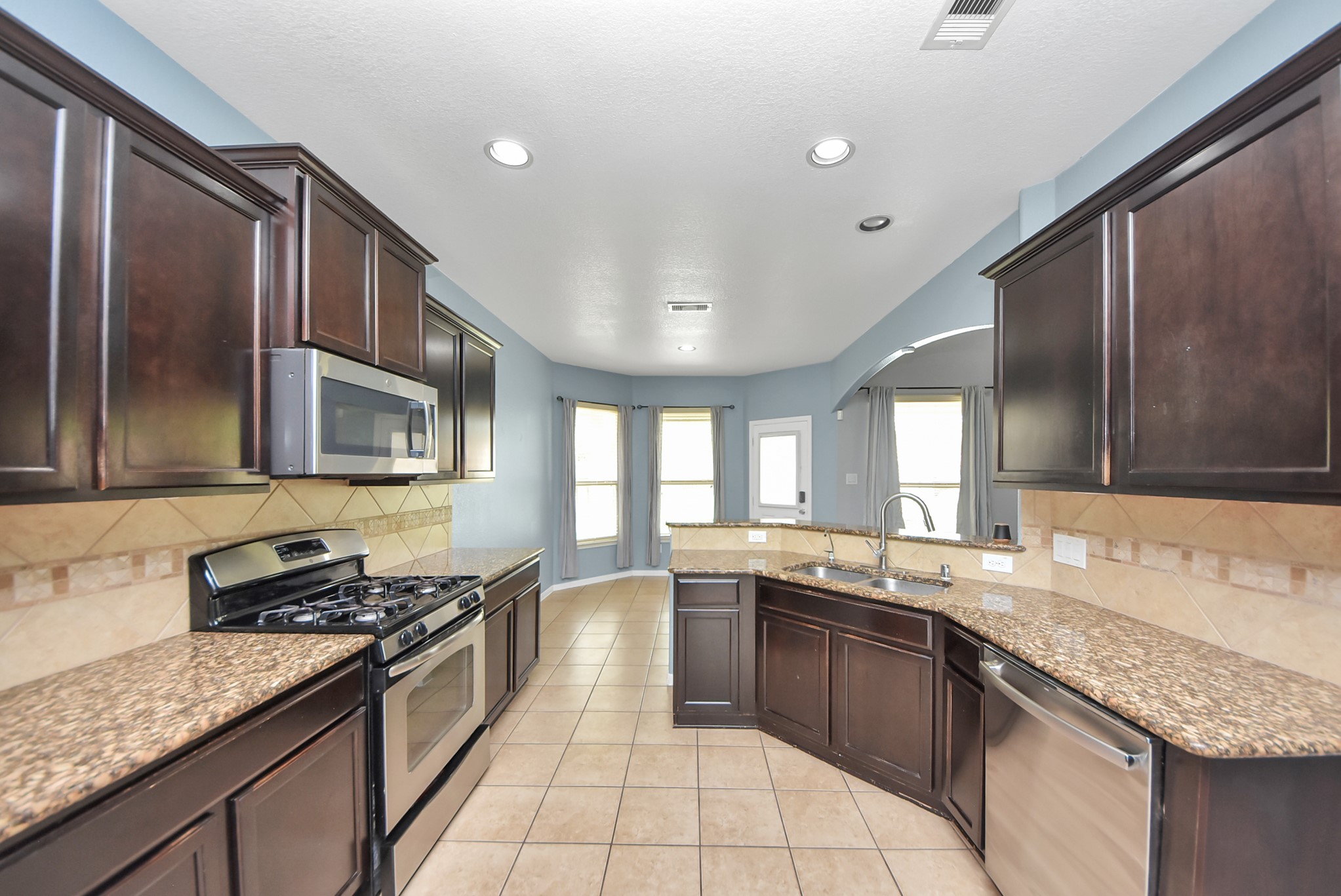 33227 Greenfield Forest Drive Spring, TX 77382 - Photo 16 of 50 a large kitchen with granite countertop a sink and a stove