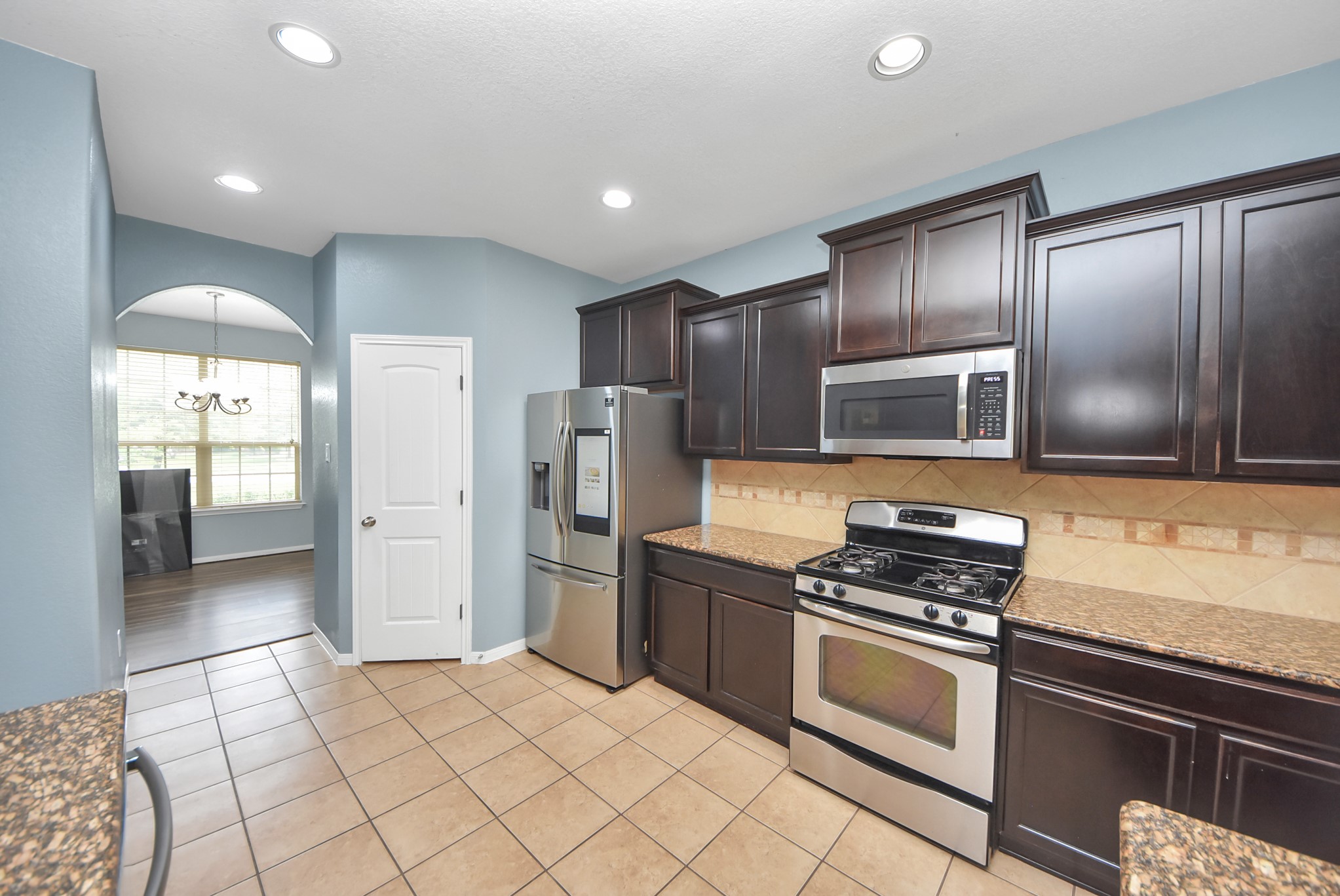33227 Greenfield Forest Drive Spring, TX 77382 - Photo 18 of 50 a kitchen with stainless steel appliances a refrigerator and a stove top oven