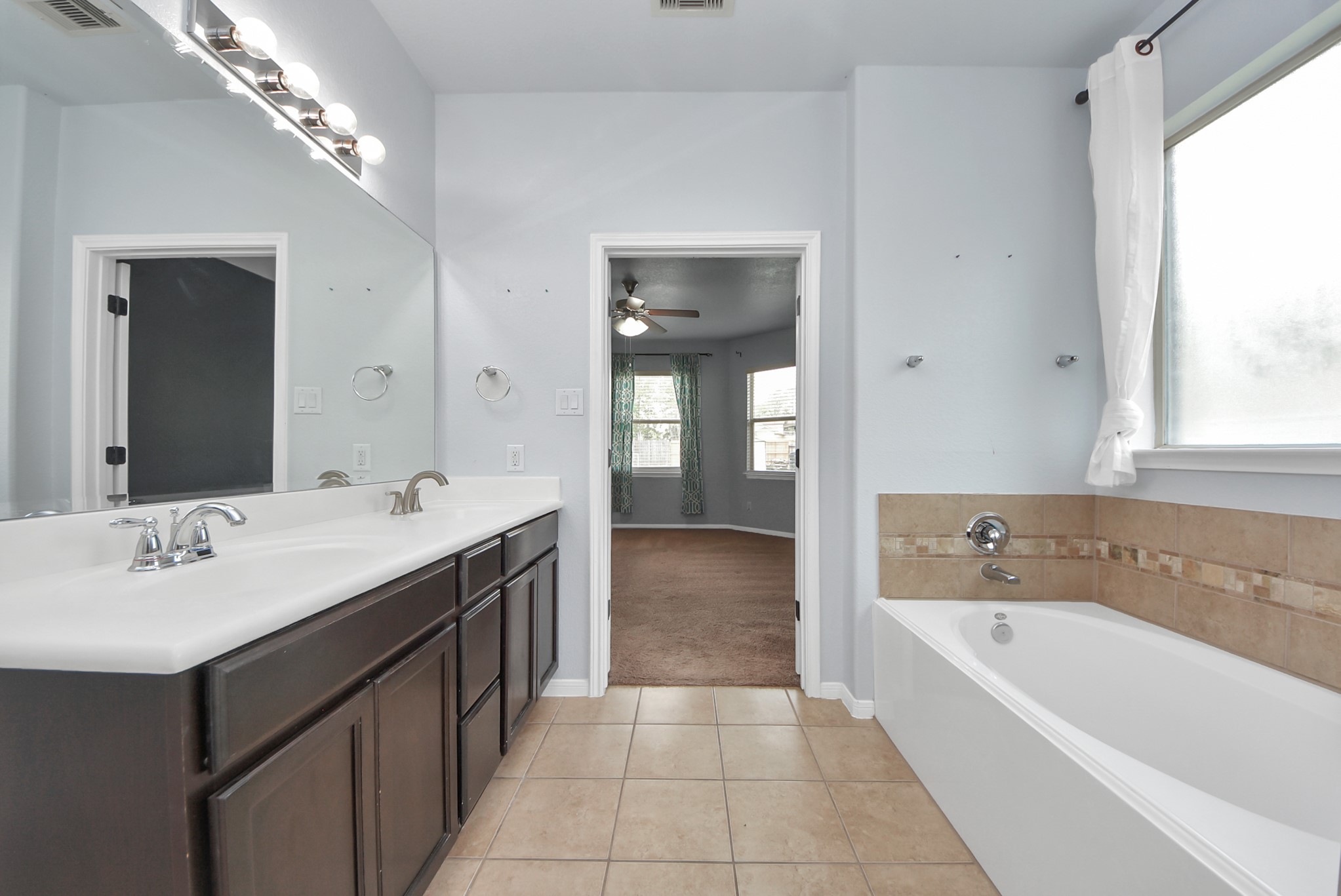 33227 Greenfield Forest Drive Spring, TX 77382 - Photo 45 of 50 a bathroom with a bathtub a double vanity sink and mirror