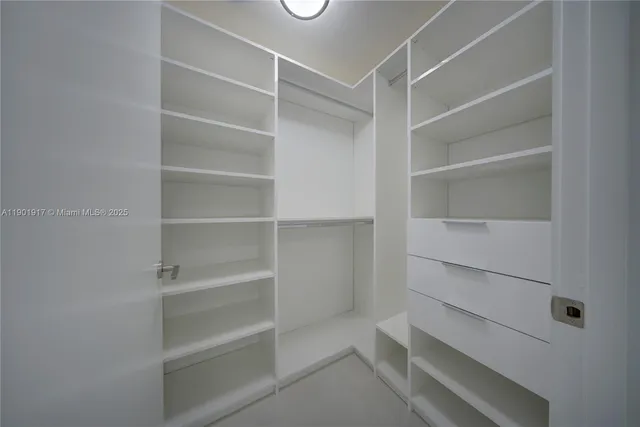 a view of walk in closet with empty racks
